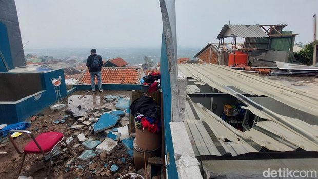 Warga membersihkan bangunan yang rusak disapu puting beliung. Warga membersihkan bangunan yang rusak disapu puting beliung.