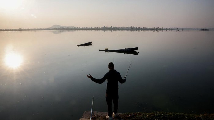 A fisherman rows his boat through a dense cover of water lilies on Dal Lake in Srinagar, Indian Kashmir, October 27, 2026. REUTERS/Sharafat Ali     TPX IMAGES OF THE DAY