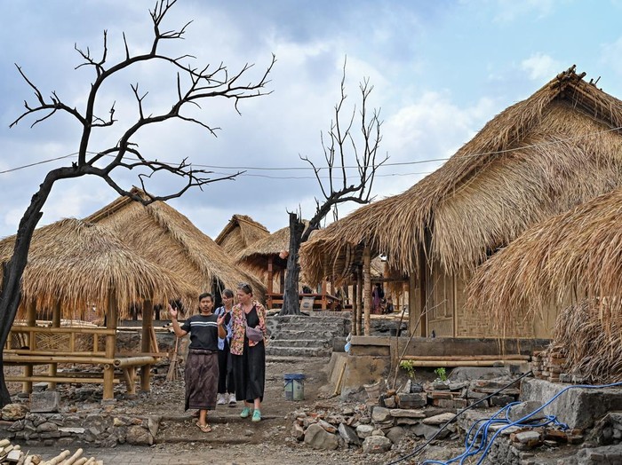 Desa wisata adat Sade mulai dikunjungi wisatawan Pemandu wisata berbincang dengan wisatawan asing saat berkunjung ke Desa wisata adat Sade, Rembitan, Kecamatan Pujut, Praya, Lombok Tengah, NTB, Rabu (28/10/2026). Dua bulan pasca kebakaran yang melanda Desa wisata Adat Sade sejumlah wisatawan mulai datang berkunjung, sementara progres pembangunan kembali 75 rumah adat yang terbakar di Sade saat ini telah mencapai 55 persen dari 75 bangunan sisa 20 yang belum terbangun.ANTARA FOTO/Ahmad Subaidi/nz