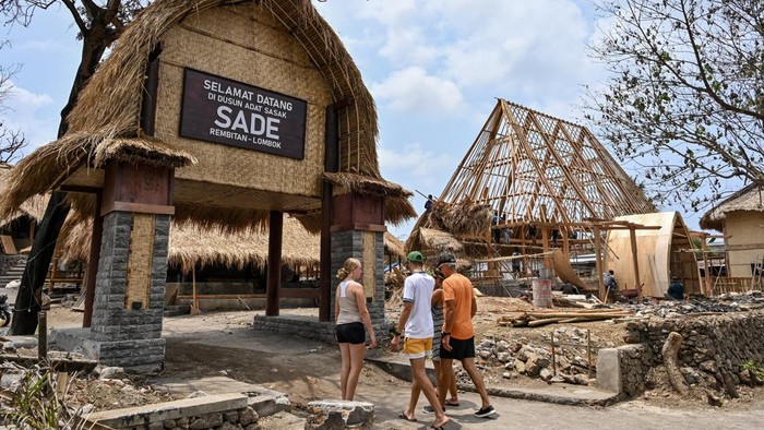 Pemandu wisata berbincang dengan wisatawan asing saat berkunjung ke Desa wisata adat Sade, Rembitan, Kecamatan Pujut, Praya, Lombok Tengah, NTB, Rabu (28/10/2026). Dua bulan pasca kebakaran yang melanda Desa wisata Adat Sade sejumlah wisatawan mulai datang berkunjung, sementara progres pembangunan kembali 75 rumah adat yang terbakar di Sade saat ini telah mencapai 55 persen dari 75 bangunan sisa 20 yang belum terbangun.ANTARA FOTO/Ahmad Subaidi/nz