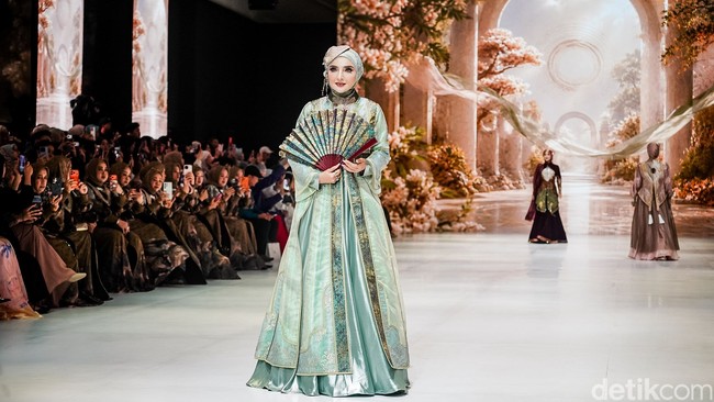 Untuk brand Lina Sukijo, Ashanti yang baru berhijab tampil sebagai model. Ia mengenakan gamis yang terinspirasi baju tradisional Tiongkok. Foto: Tsaltsabillah Khairunissa