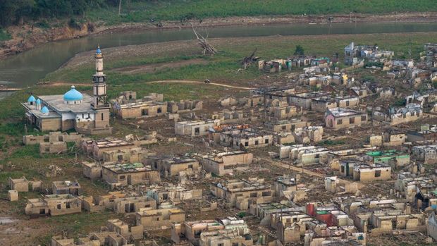 Tampilan dari drone memperlihatkan sisa-sisa rumah dan masjid Al Mujahiddin di Desa Somang yang muncul kembali setelah permukaan air di waduk Karian—yang memasok air untuk wilayah sekitarnya termasuk Jakarta—menurun akibat kekeringan berkepanjangan yang dipicu oleh fenomena El Nino, di Lebak, Provinsi Banten, Indonesia, 23 Oktober 2026. (REUTERS/Willy Kurniawan)