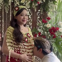 Ikuti tradisi adat Jawa, di prosesi siraman Jodie tampil kenakan kain jumputan berwarna merah, lengkap dengan cape dan bandana ronce melati. Sementara suaminya tampil dengan beskap putih dipadukan dengan kain lilit batik coklat dan blangkon untuk menutup kepalanya.&nbsp;Foto: Instagram/@brisiajodie96
