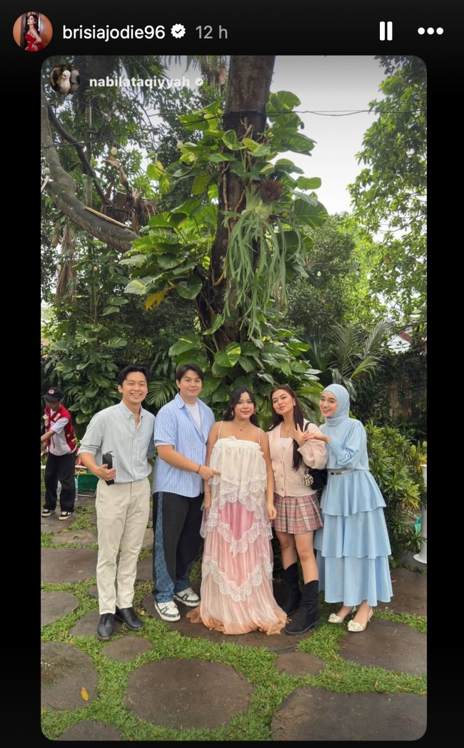 Alden tampil mengenakan kemeja biru dipadukan dengan dalaman kaos putih dan celana panjang senada. Sementara Jodie mengenakan dress panjang tali spaghetti. Dress tersebut bernuansa putih dan pink dengan model ruffle dan lace.&nbsp;Foto: Instagram/@brisiajodie96