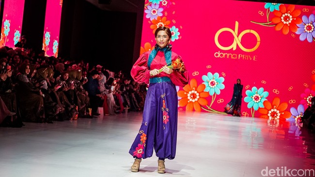 Fashion show Donna Prive bertabur model selebriti. Ussy Sulistiawati berpose dengan bunga saat mengenakan setelan berpotongan balon yang mencuri atensi. Foto: Tsaltsabillah Rahmadhani / detikfoto