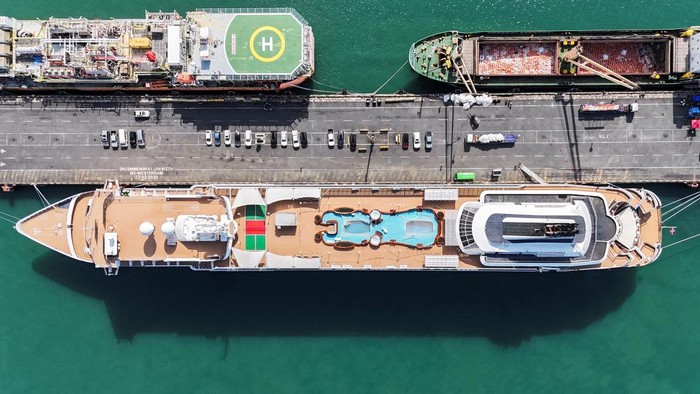 Niat Keliling Dunia 3,5 Tahun, Ratusan Penumpang Kapal Pesiar Telantar di Kamboja Drone view of the Villa Vie Odyssey cruise ship docking at Sihanoukville Autonomous Port, after permanent residents living aboard the vessel were forced to disembark in Cambodia, as the operator said rising fuel prices linked to conflict involving Iran had made operations prohibitively expensive, in Preah Sihanouk province, Cambodia, October 28, 2026. REUTERS/Soveit Yarn