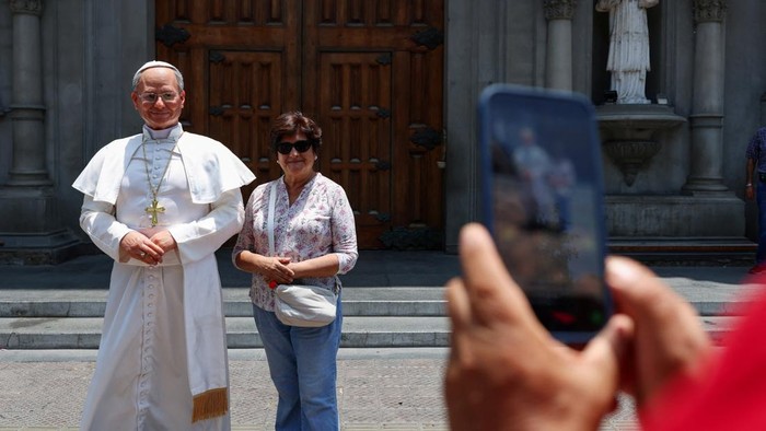 A woman takes a selfie with a silicone statue of Pope Leo, created by Peruvian artist Walt Wizard, outside a Catholic church ahead of the Popes November visit to Peru and other South American countries, in Lima, Peru, October 28, 2026. REUTERS/Stifs