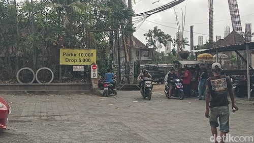 Spanduk kuning bertuliskan tarif parkir di depan gang gajah biru, Ubud, Jumat (30/10/2026). (Aryo Mahendro/detikBali).