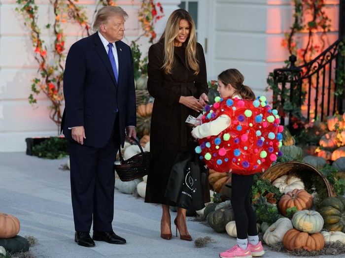 USA-TRUMP/ US President Donald Trump and first lady Melania Trump hand out sweets to a child at a Halloween event at the White House in Washington, DC, US, October 29, 2026. REUTERS/Umit Bektas