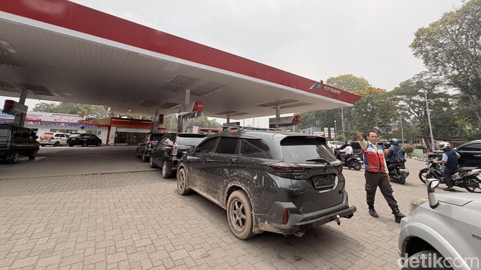 Feriadi, petugas marshal di SPBU Coco Pertamina Plaju Palembang saat bertugas mengatur antrean kendaraan konsumen.
