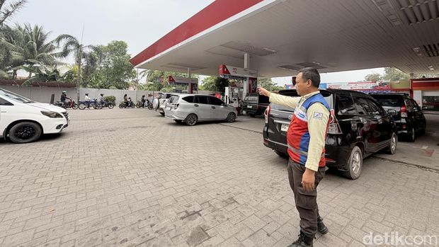 Marshal di SPBU Coco Pertamina Plaju Palembang saat bertugas mengatur antrean kendaraan konsumen.