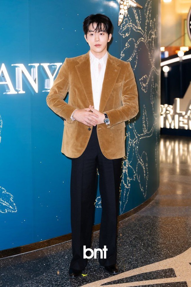 Dalam kesempatan itu, Nam Joo Hyuk memancarkan pesonanya tampil dalam balutan kemeja putih dan setelan jas coklat berbahan suede. Beberapa helai poni membingkai wajah aktor dengan tinggi semampai mencapai 188 cm. Foto: dok. X @NamJooHyukTH