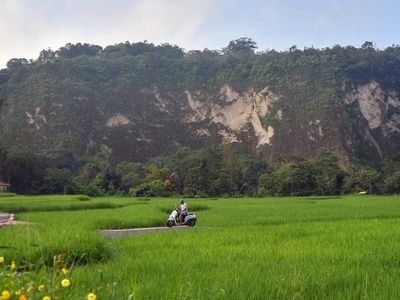 Warga melintasi jalan di area persawahan kawasan agrowisata Geopark Ngarai Sianok, Bukittinggi, Sumatera Barat, Sabtu (31/10/2026). Kawasan agrowisata yang dikelola melalui kolaborasi Kelompok Tani (Poktan) Ngarai Saiyo dan Kelompok Sadar Wisata (Pok