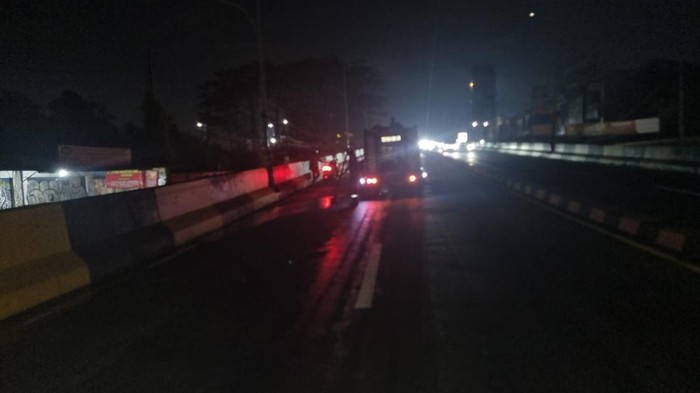 Petugas membersihkan tumpahan oli yang bikin kecelakaan beruntun di Flyover Gaplek, Tangerang Selatan, Kamis (30/10/2026).
