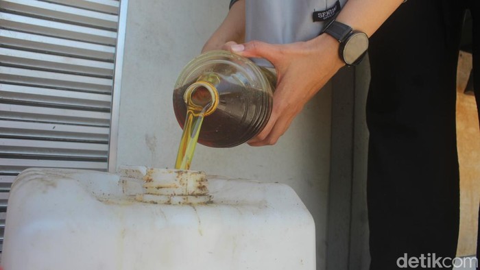 Warga Cileunyi menuangkan minyak jelantah ke jeriken untuk diolah menjadi biofuel