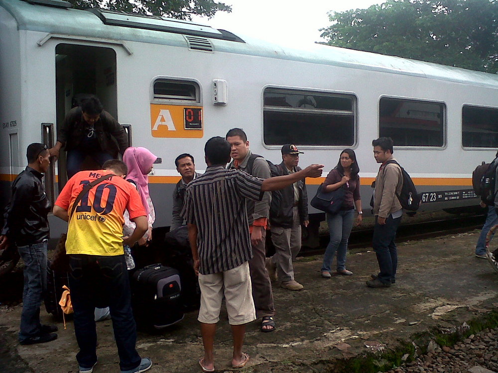 Pemandangan udara luas yang menunjukkan kota yang terendam banjir parah dengan genangan air di jalan-jalan dan bangunan-bangunan, dengan kereta api terhenti di jalur yang tergenang di kejauhan.
