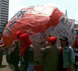 Buruh Gelindingkan Bola Raksasa