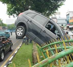 Mobil Chevrolet Nyangkut di Atas Pagar Jl Sudirman Pekanbaru