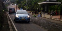 Lapisan aspal Jalan Sudirman yang dahulu mulus kini penuh lubang-lubang menganga.