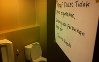 Di pintu toilet ini memang terpasang tulisan Maaf Toilet Tidak Dapat Digunakan, Masih Perbaikan Pipa. Aliran air kran juga mati.
