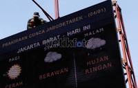 Seorang pekerja memasang gipsum pada papan petunjuk prakiraan cuaca di taman kota Gambir, Jakarta Pusat. Menurut Kasubid Informasi Meteorologi BMKG, Hary Tirto Djatmiko, Januari termasuk dalam kategori intensitas tinggi curah hujan.