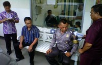 Sopir mobil pengisi ATM dan polisi pengawal, Bripka Eko SW, memerankan tengah duduk menunggu dua petugas pengisi ATM.