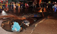 Petugas memeriksa reruntuhan jalan yang amblas.