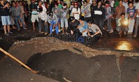 Meski sudah dilarang dan diberi garis polisi, warga yang penasaran nekat melihat jalan yang amblas dari dekat. Hal ini tentu sangat membahayakan diri mereka.