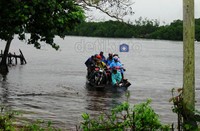 Rombongan warga dengan sepeda motornya menyeberangi Teluk Kalong dengan perahu bangkong.