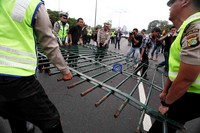 Beberapa polisi berusaha mengamankan pagar yang dirobohkan pendemo.