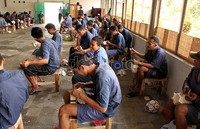 Mereka duduk di kursi kayu saat akan menjahit.