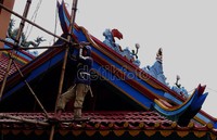 Seorang pekerja tengah menyelesaikan renovasi bangunan klenteng. Rengga Sancaya/detikcom.