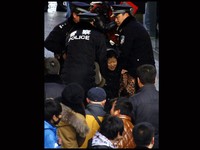 Polisi membubarkan pengentre yang memadati halaman toko Apple di distrik Sanlitun, Beijing. Reuters/David Gray.