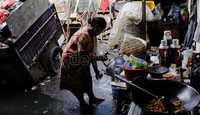 Seorang ibu sedang menuangkan air yang akan digunakan untuk memasak. Hasan Alhabshy/detikcom.