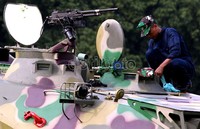Seorang prajurit membersihkan kendaraan tank TNI jenis APC Amphibi.