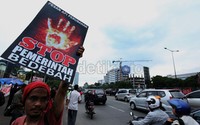 Salah seorang demonstran memegang poster bertuliskan Stop Pemerintah Bedebah.
