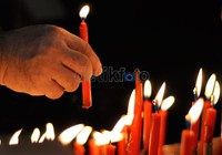 Seorang warga Tionghoa memasang lilin di dalam Klenteng Xian Ma, sebagai tanda pengharapan hidup yang lebih baik di tahun ini.