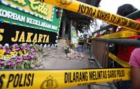 Selain karangan bunga, garis polisi terlihat di lokasi.
