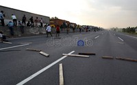 Balok-balok kayu berserakan di tol Cikarang. Sebelumnya, balok-balok kayu itu akan digunakan oleh warga untuk melawan buruh.