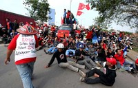 Dalam aksi long marchnya di Jalan Cibarusah Raya, Cikarang, para buruh saling bergandengan tangan menyatukan kekuatan mereka menutut Apindo.