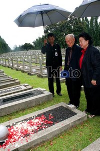Lee dan isteri memanjatkan doa di depan makam.