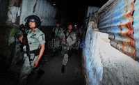 Anggota Kepolisian Brimob dengan membawa senjata, memasuki gang wilayah Jalan Kapten Tendean, Jakarta Selatan, Sabtu (28/01) dinihari, untuk melakukan sweeping ormas FBR dan PP.