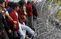 Mahasiswa berusaha merusak kawat berduri yang dipasang di depan Istana.
