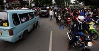 Pengendara harus berjalan lambat karena banyaknya pengunjung dan peliput yang ingin menuju ke rumah duka Ade Namnung.