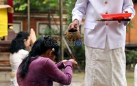 Pemangku menyiramkan air kepada umat Hindu dalam perayaan Galungan di Pura Aditya Jaya, Rawamangun, Jakarta.