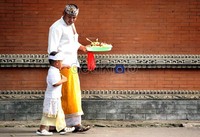 Bapak bersama anaknya membawa cana yang berisi dupa dan kembang untuk merayakan Galungan di Pura Aditya Jaya, Rawamangun, Jakarta.