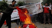 Dalam aksinya, massa membakar baju berlogo Telkomsel.