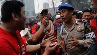 Polisi berusaha menenangkan demonstran.