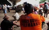 Seorang ibu salah satu penghuni bangunan liar, memakai kaos kampanye Fauzi Bowo menyaksikan Satpol PP membongkar rumahnya. Menurutnya Foke hanya janji-janji palsu untuk melindungi dan mensejahterkan warga DKI.