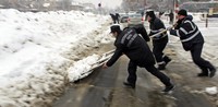 Petugas pemadam kebakaran Rumanis menyingkirkan salju yang menutupi jalan. Reuters/Radu Sigheti.